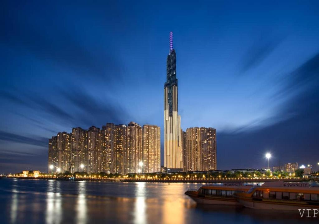胡志明市Landmark 81 Infinity Pool - VIP Apartment的一座高耸的摩天大楼,晚上有一座城市