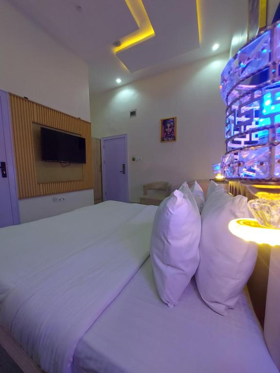 拉各斯Soulmate Hotels & Suites的卧室配有一张带白色床单和枕头的大床。