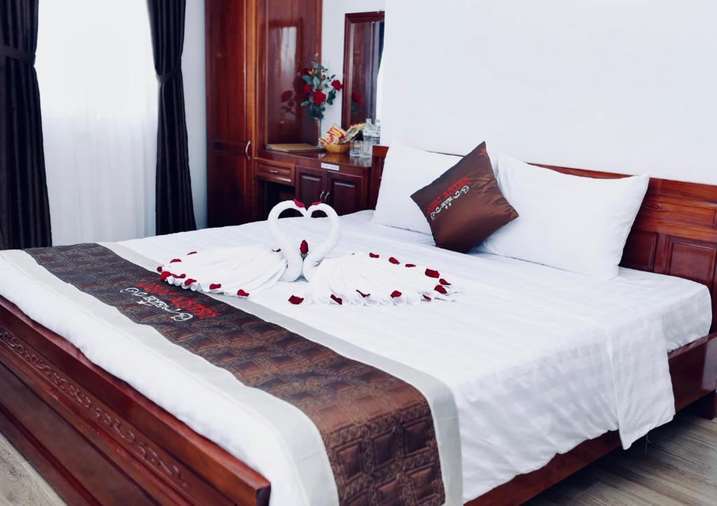 岘港Quốc Khánh Hotel Da Nang的一间卧室,床上有红色玫瑰