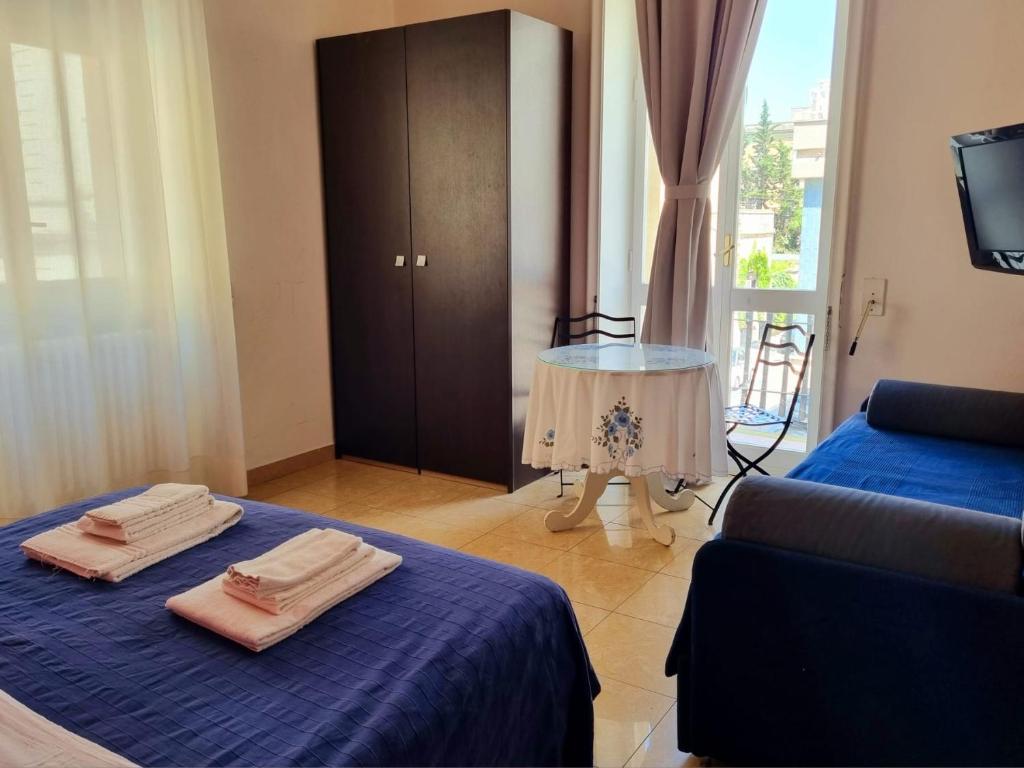 莱切H Central Lecce的客房设有两张床、一张沙发和一张桌子。