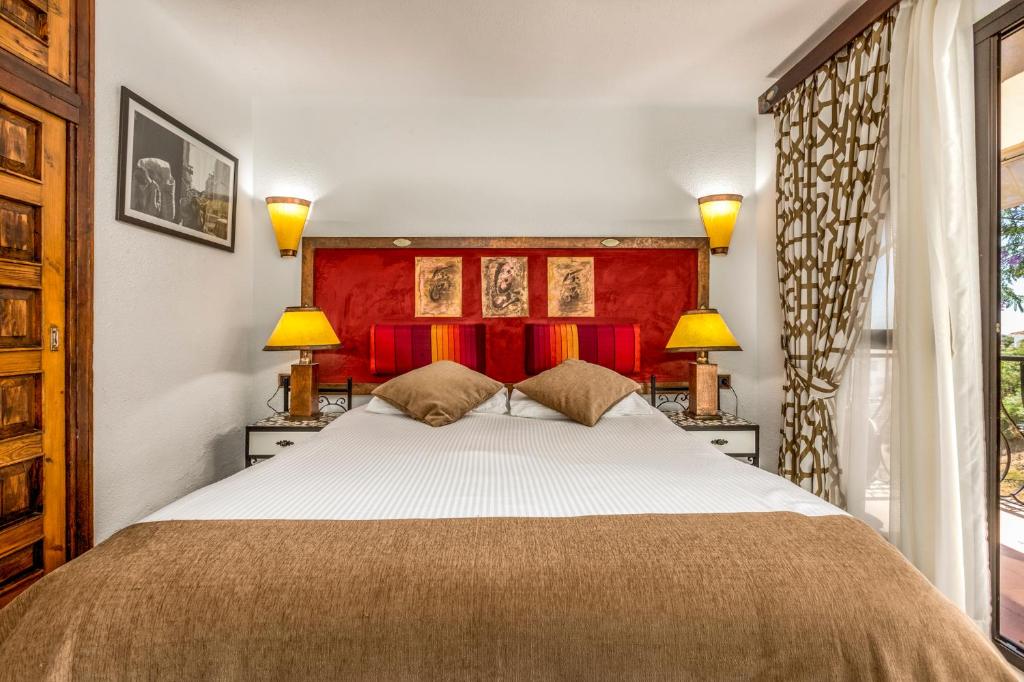 福恩吉罗拉Boutique Hotel Las Islas的一间卧室配有一张大床和两盏灯
