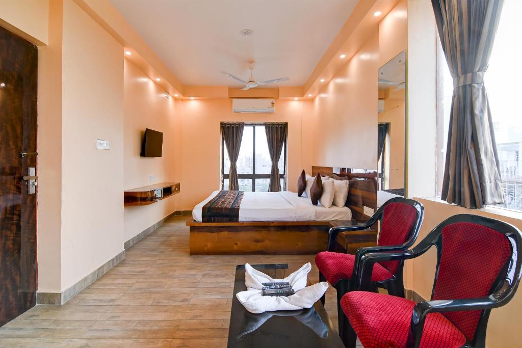 kolkataEco Corporate Inn 2 Rajarhat的酒店客房,配有一张床和两把椅子