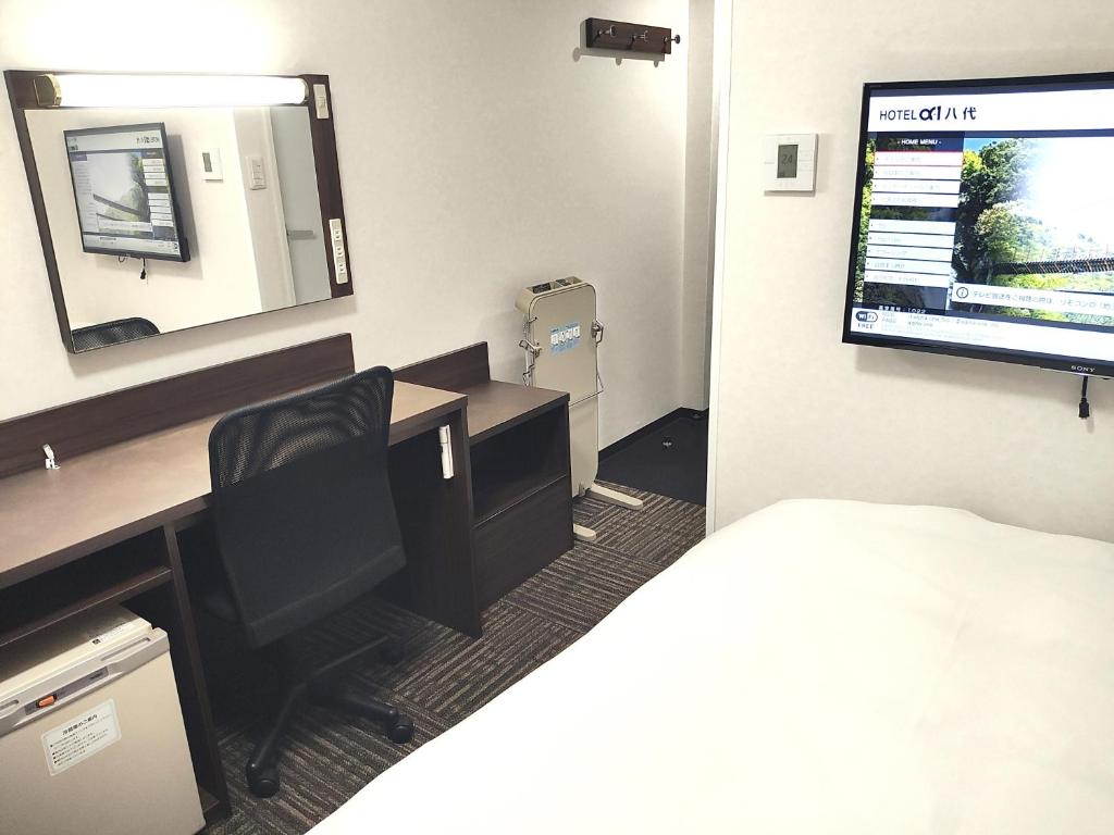 八代市Hotel Alpha-One Yatsushiro的客房设有一张带电脑和镜子的书桌