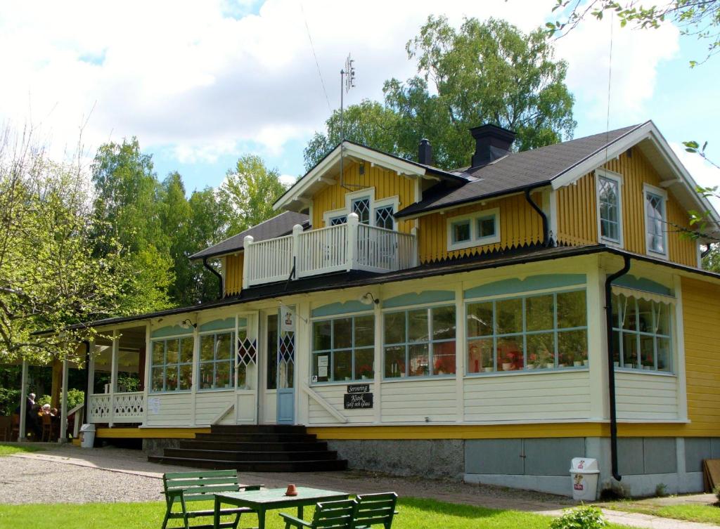 萨拉Sofielund Vandrarhem & Camping的一座黄色的大房子,前面有一张桌子