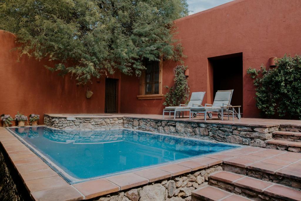 克雷塔罗Hotel Casa De Quino的一座游泳池,位于一座建筑旁的院子内