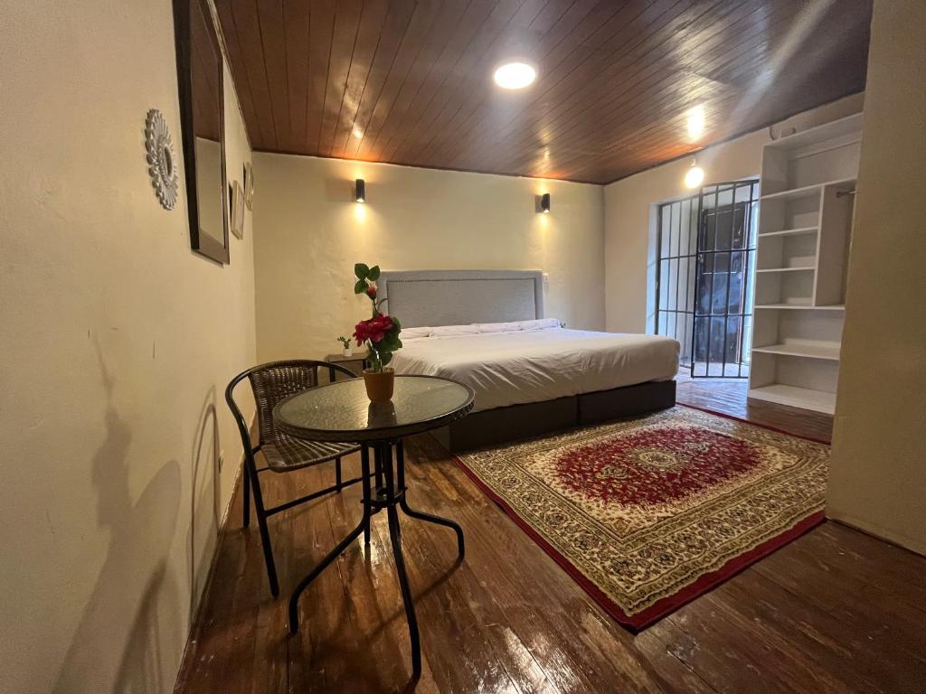 库斯科Casa Virgen del Carmen的一间小卧室,配有床、桌子和地毯