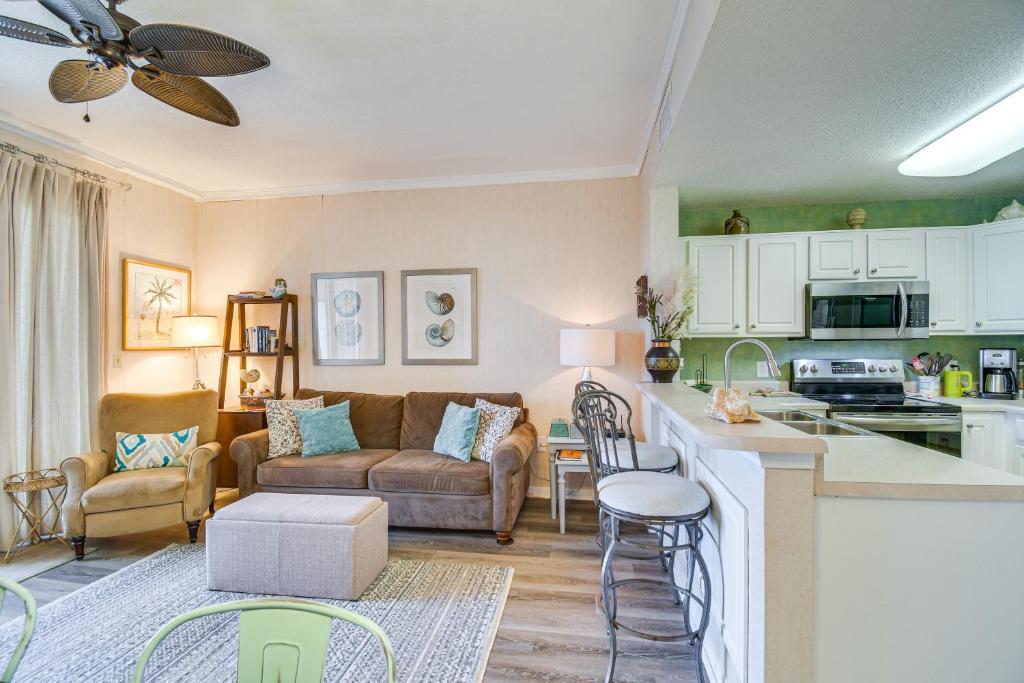 格尔夫海岸Gulf Shores Condo with Balcony 2 Mi to Fort Morgan!的配有沙发和桌子的厨房和客厅