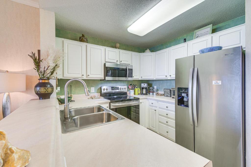 格尔夫海岸Gulf Shores Condo with Balcony 2 Mi to Fort Morgan!的配有白色橱柜和不锈钢冰箱的厨房