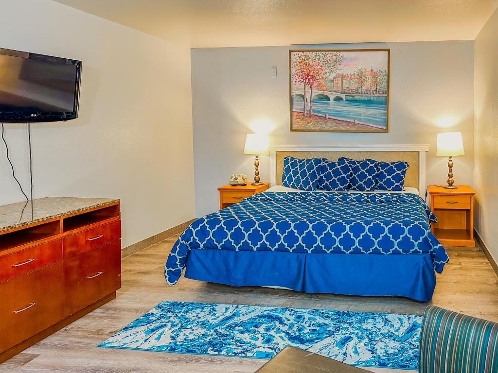 肖尔莱恩Americas Inn & Suite的一间卧室配有蓝色的床和一台平面电视