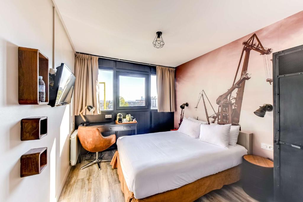 圣纳泽尔圣纳泽尔中心布里特酒店的一间卧室配有一张床、一张桌子和一张床
