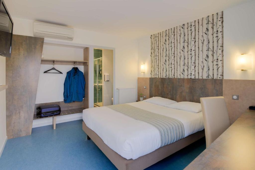 考奇Brit Hotel Hermes的一间卧室设有一张大床,铺有蓝色的地板。