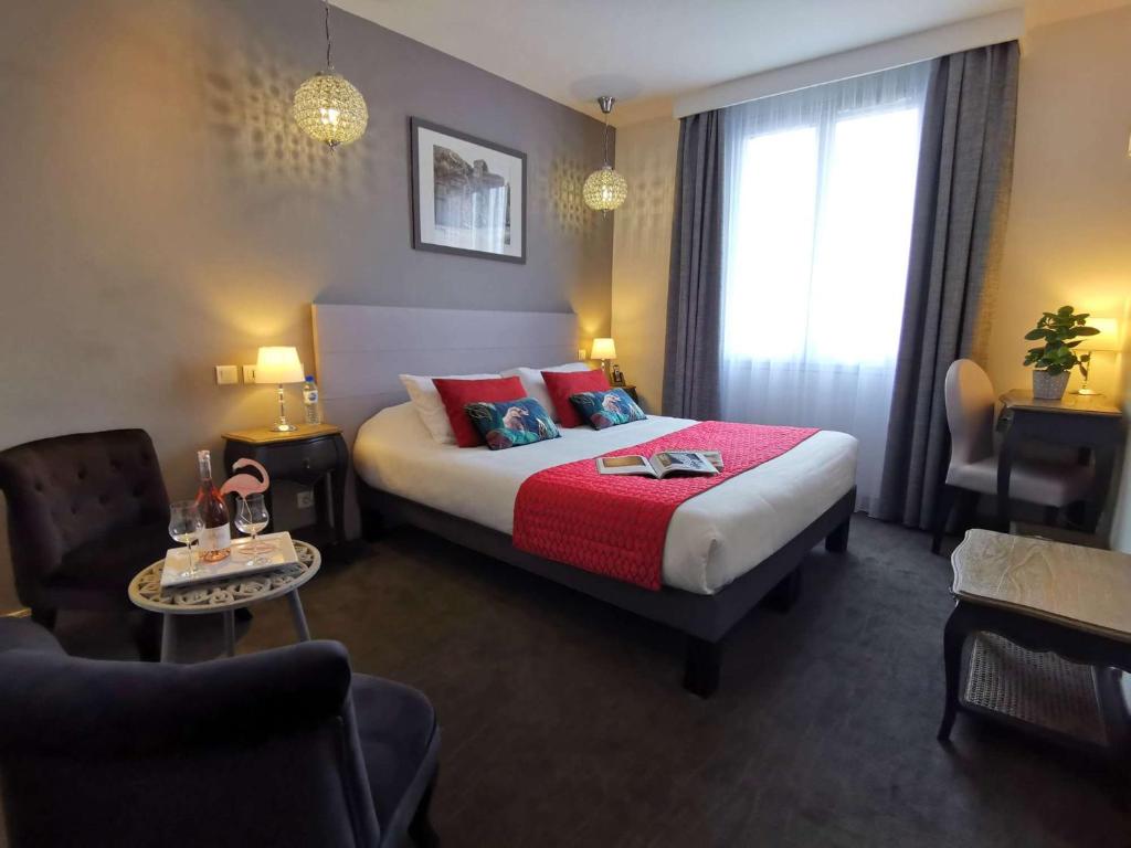 阿尔勒Brit Hotel Acacias的酒店客房,配有一张带红色毯子的床