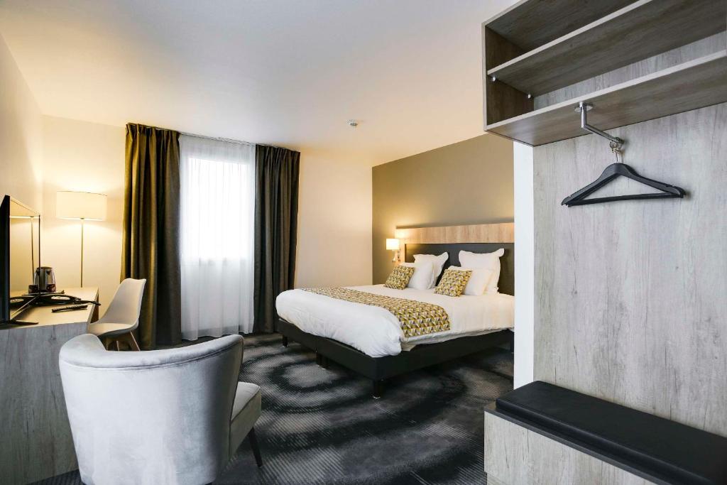 洛什Brit Hotel Confort Loches的配有一张床和一把椅子的酒店客房