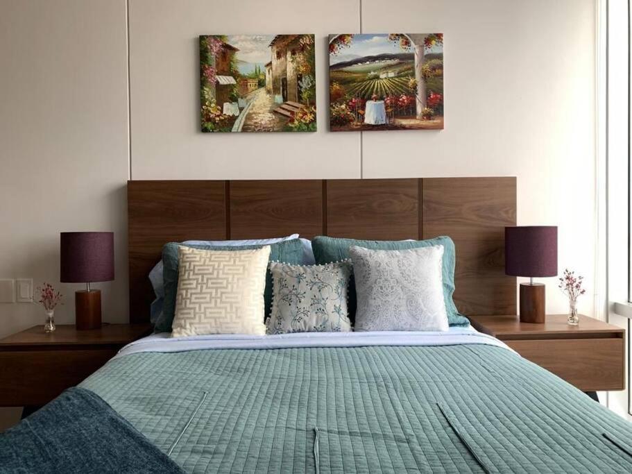 墨西哥城Olivo Apartment HP - Sur的卧室配有一张壁画和两张画的床铺。