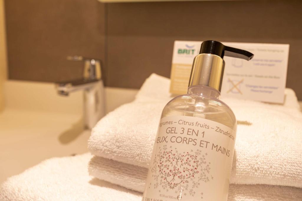 普洛埃尔梅勒Brit Hotel Ploermel - Hotel de l'Hippodrome的浴室水槽上方的肥皂瓶