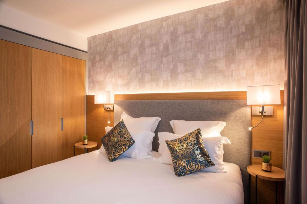 蒂艾Brit Hotel Paris Orly Rungis的卧室配有一张带两个枕头的大白色床