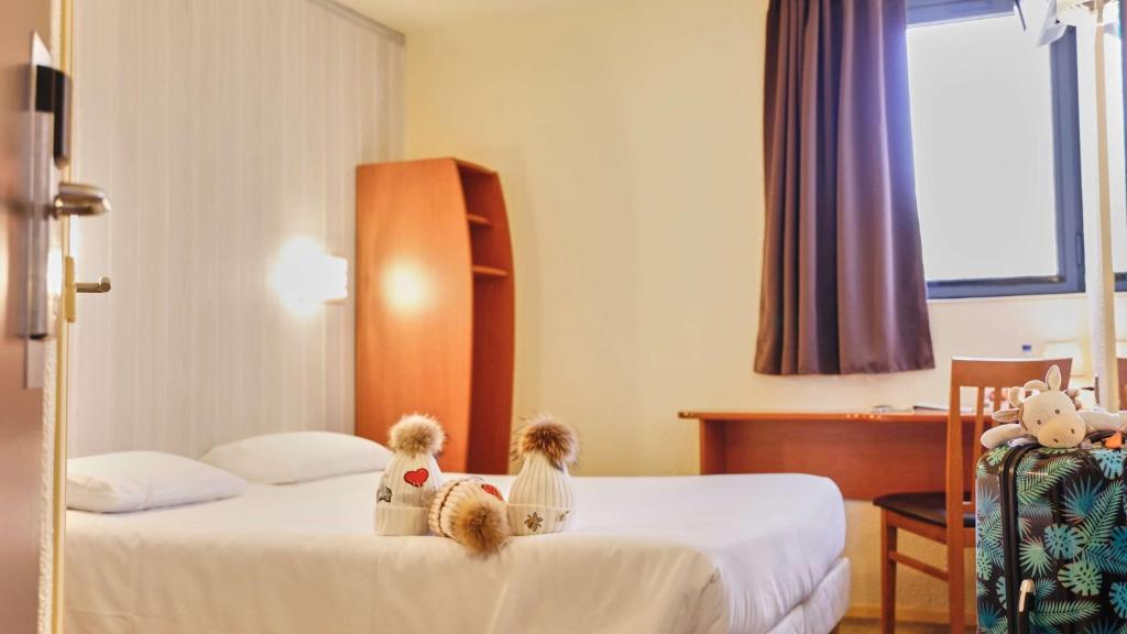 尚贝里尚贝里布里特酒店的两个泰迪熊坐在酒店房间的床边
