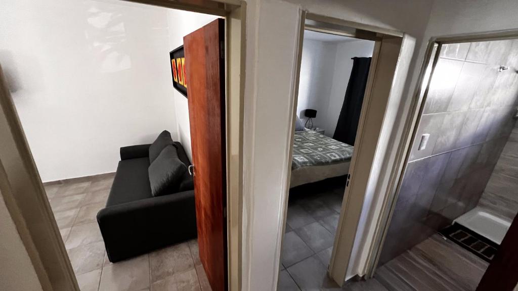 科尔多瓦Apartamento poeta lugones的带镜子和沙发的房间以及一间卧室