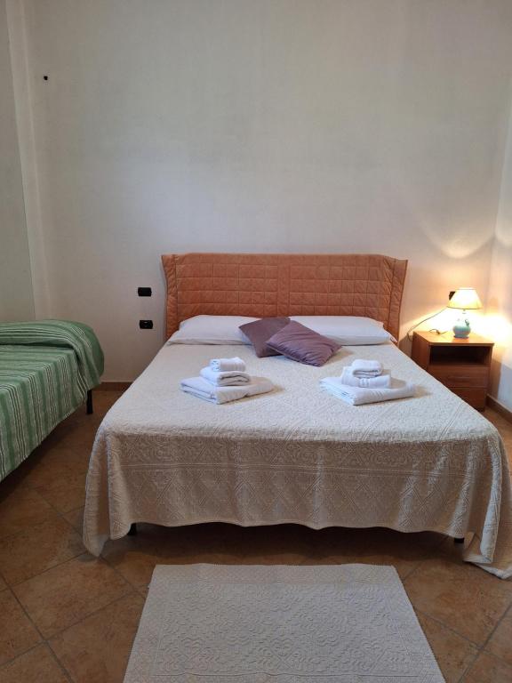 IrgoliCasa vacanze Irgoli的一间卧室配有带毛巾的床