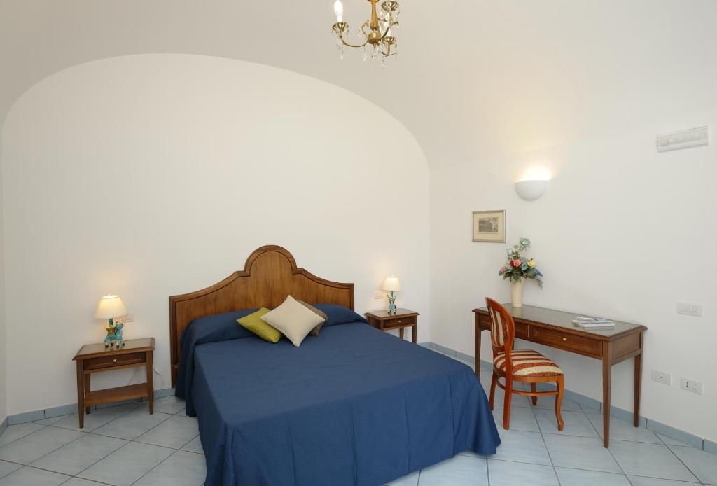 拉维罗艾尔杜卡托蒂拉维洛酒店的一间卧室配有一张蓝色的床、一张桌子和一把椅子