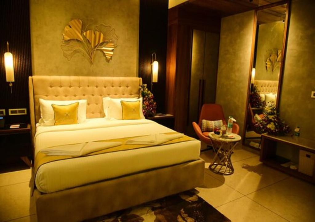 新德里Hotel Seven Inn (R S Gorup Near Delhi Airport)的一间卧室配有一张大床和一张桌子
