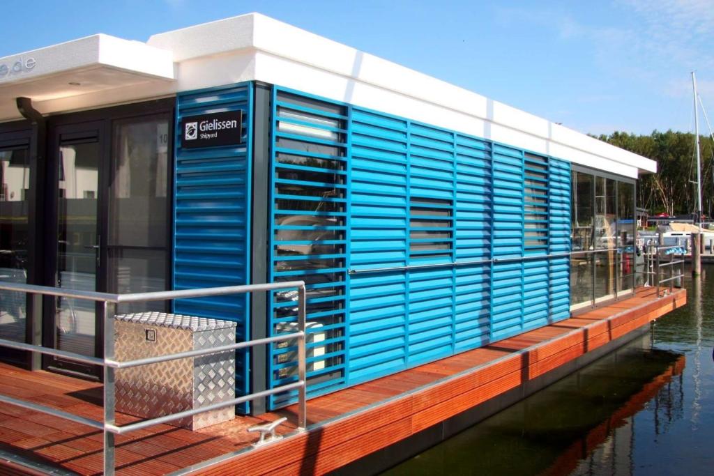 佩讷明德Hausboot Marama - LP10的水边码头上的蓝色建筑