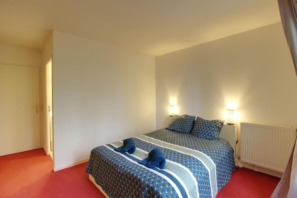 塞里斯Bel appartement situé face à la Vallée Shopping à quelques minutes de Disney的一间卧室配有一张带蓝色枕头的床