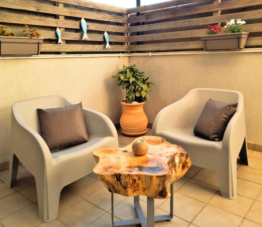 埃斯塔蒂特Apartamento Lliris Sol的两把椅子和一张茶几,树柱