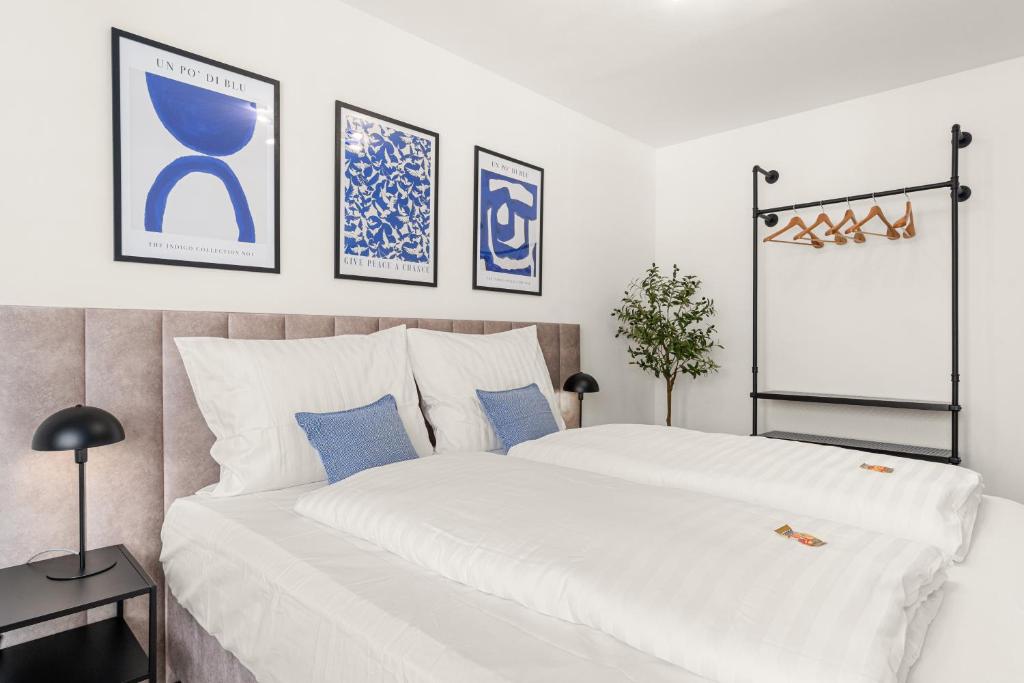 卡塞尔BLU APARTMENT -modern interior design in city centre- Nähe Uni & HBF的卧室配有一张蓝色色调的大型白色床。