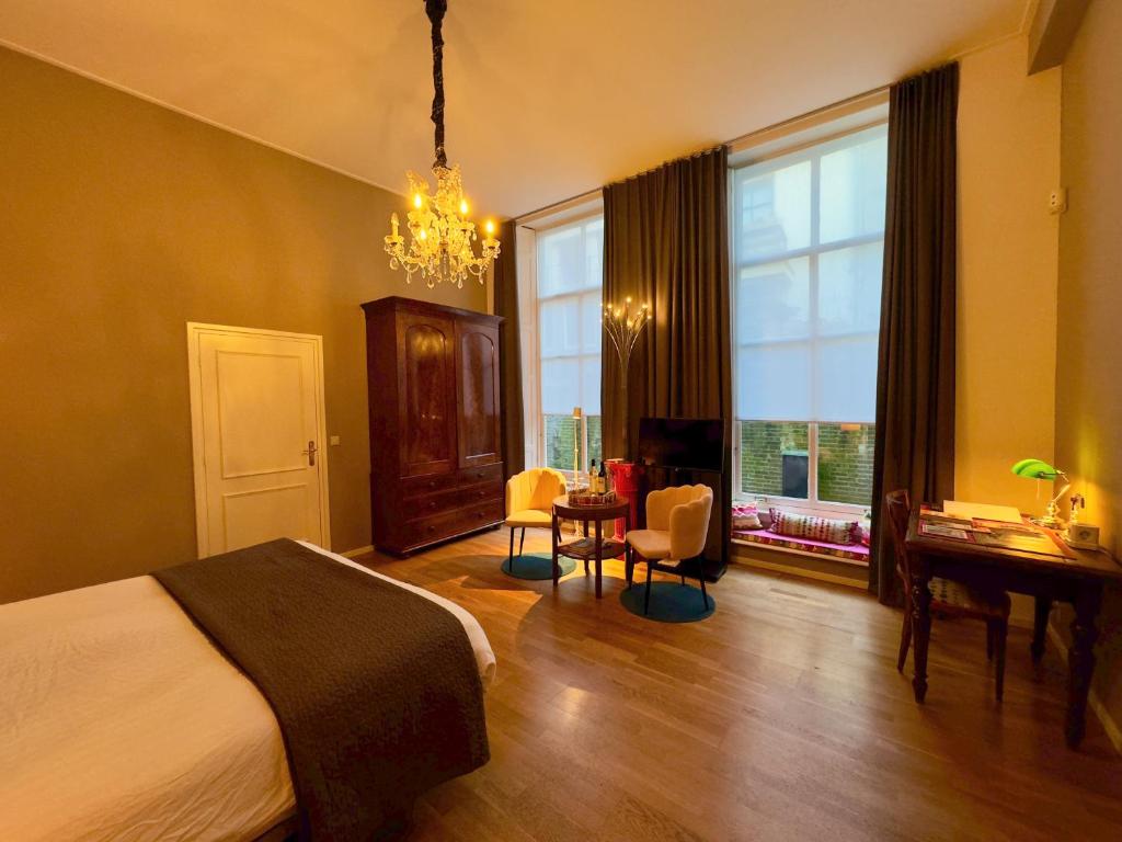 聚特芬Kerkstraatje3的卧室配有一张床、一张书桌和窗户。