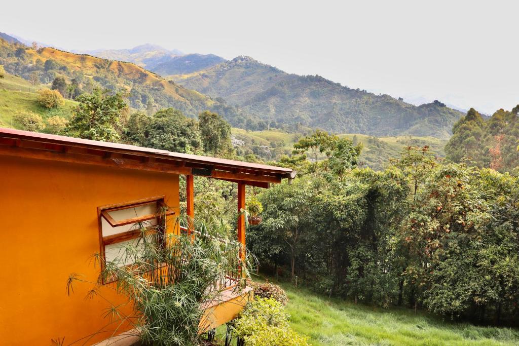 萨兰托Ecoresort Gran Azul的一座位于山丘上的橙色房子,背景是群山
