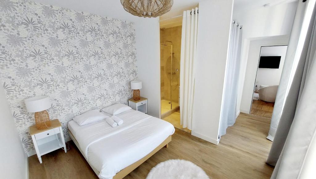 格勒诺布尔Hyper-centre de Grenoble, suite parentale - wifi fibre - cocon的卧室配有白色的床和墙壁