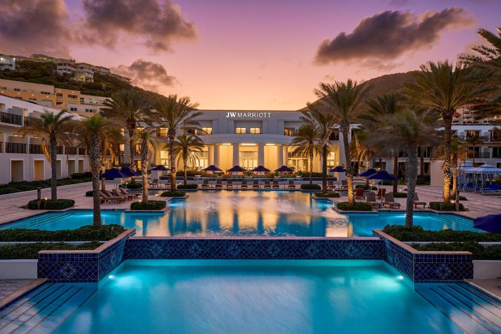 黎明海滩JW Marriott St Maarten Beach Resort & Spa的棕榈树和建筑的度假游泳池
