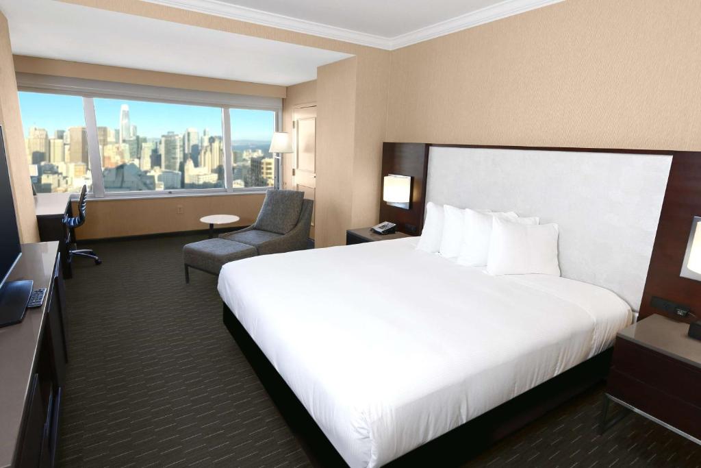 旧金山旧金山联合广场希尔顿酒店的酒店客房,配有白色的床和椅子