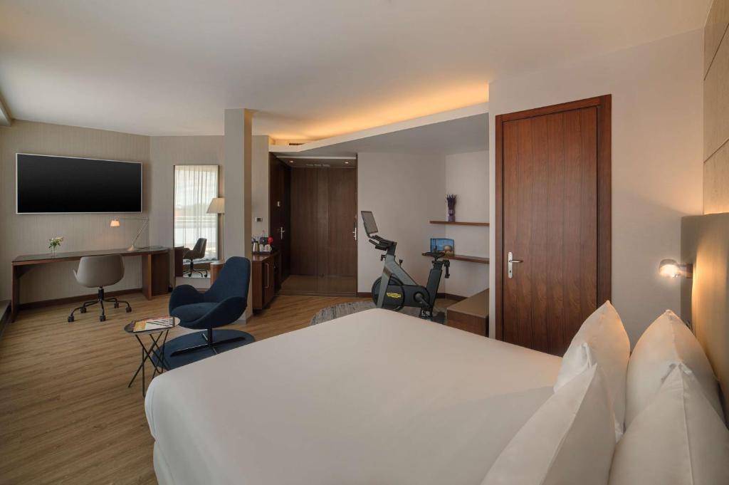 博洛尼亚NH博洛尼亚德拉葛雷酒店的酒店客房设有一张白色大床和一张书桌