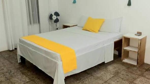 卡维塔rooms megi terminal的一张白色的床,上面有黄色枕头