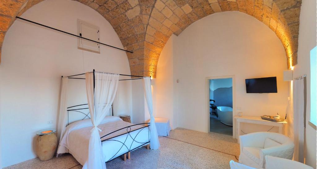 加利亚诺德尔卡波Holiday home La Corte dei Pirri的一间卧室,卧室内配有一张天蓬床