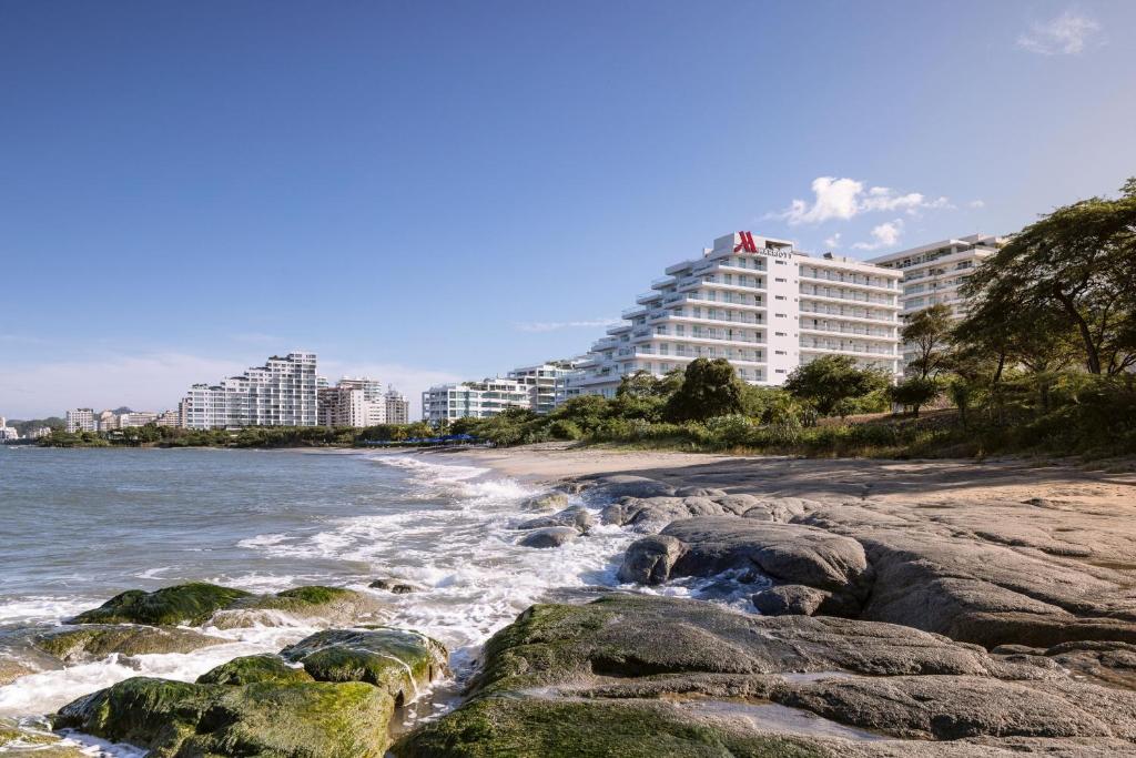 圣玛尔塔Santa Marta Marriott Resort Playa Dormida的享有海滩的景色,拥有一些岩石和建筑