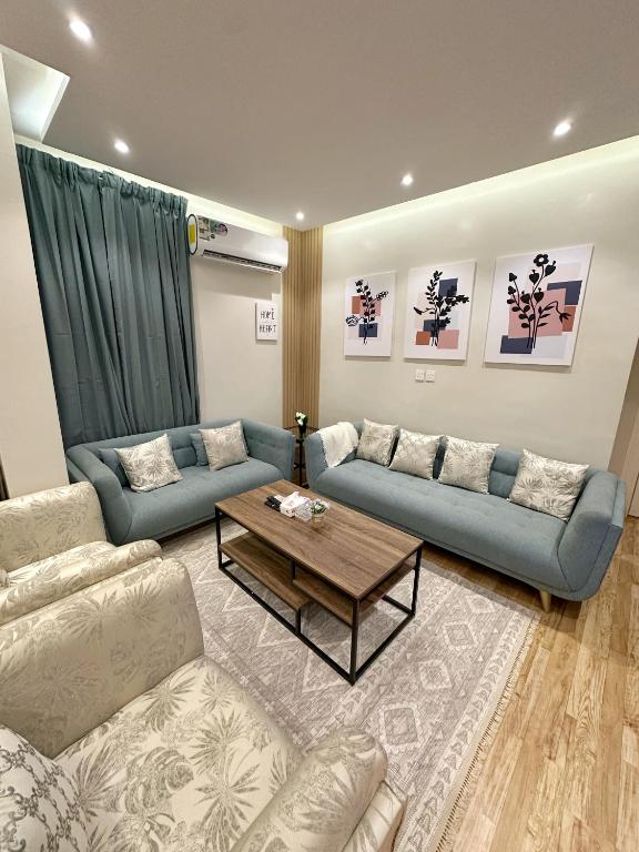 利雅德106 A شقة جميلة بغرفتين نوم ودخول ذاتي的客厅配有蓝色的沙发和咖啡桌