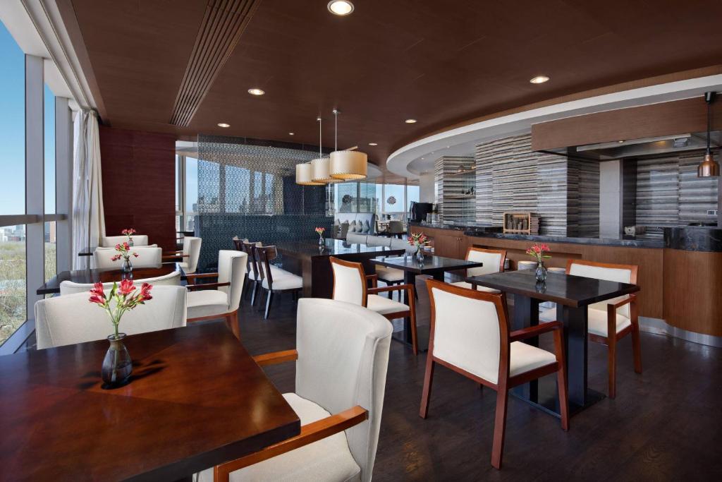 北京北京海航大厦万豪酒店的用餐室配有桌子和白色椅子