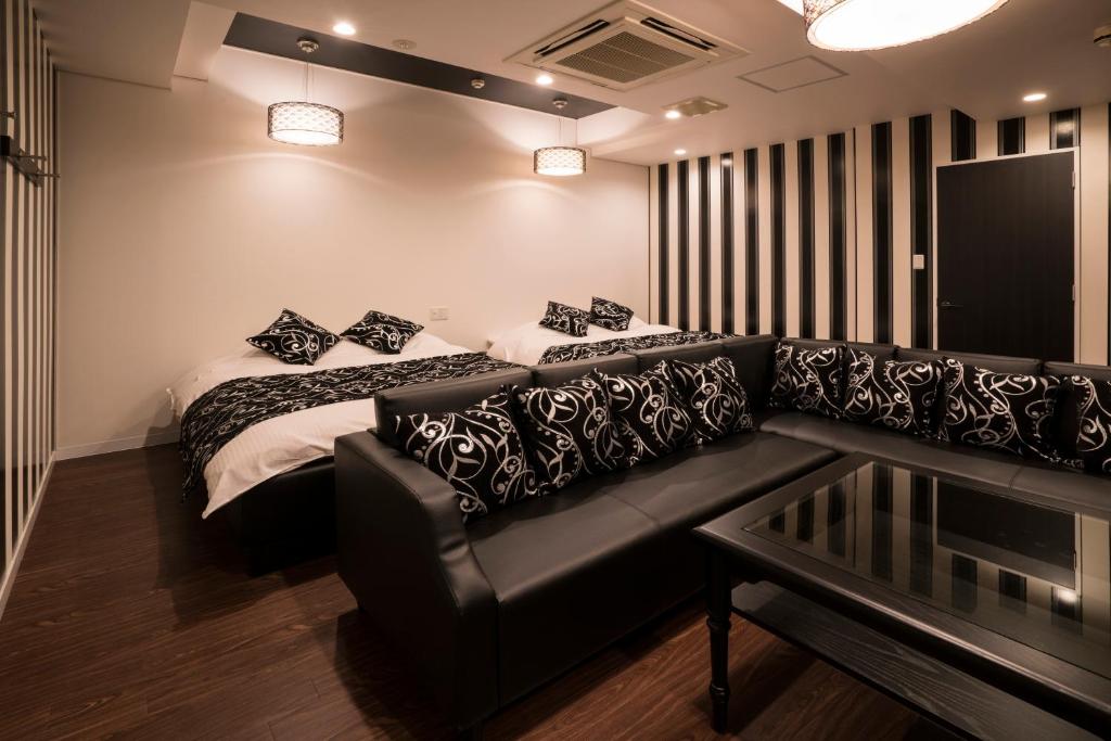 尼崎市Xenia Amagasaki的客厅配有沙发和1张床
