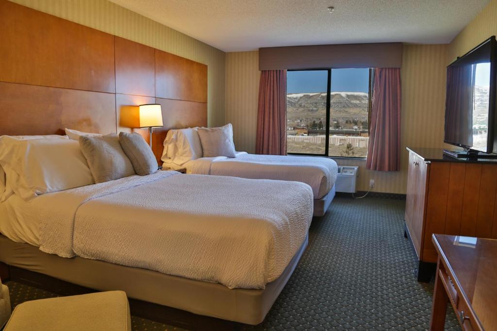 罗克斯普林Sweetwater Lodge - Rock Springs - Green River的酒店客房设有两张床和窗户。