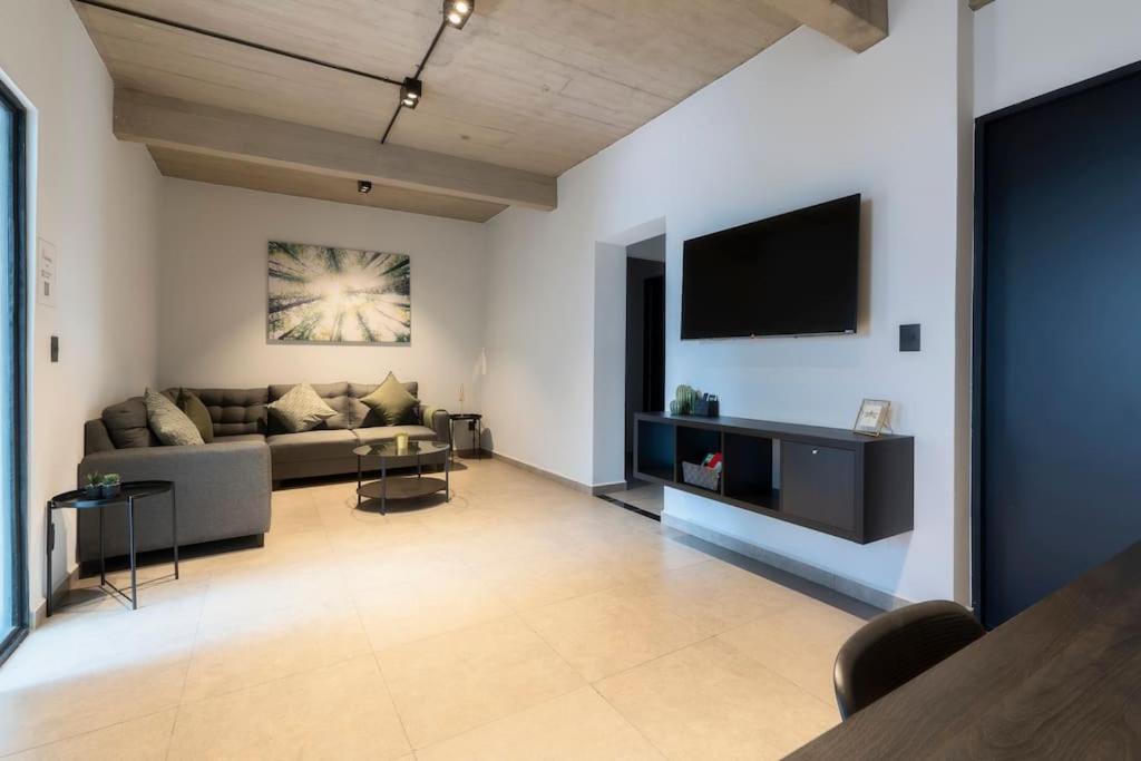 墨西哥城P502 Rooftop views 33drm 2bath AC的带沙发和平面电视的客厅