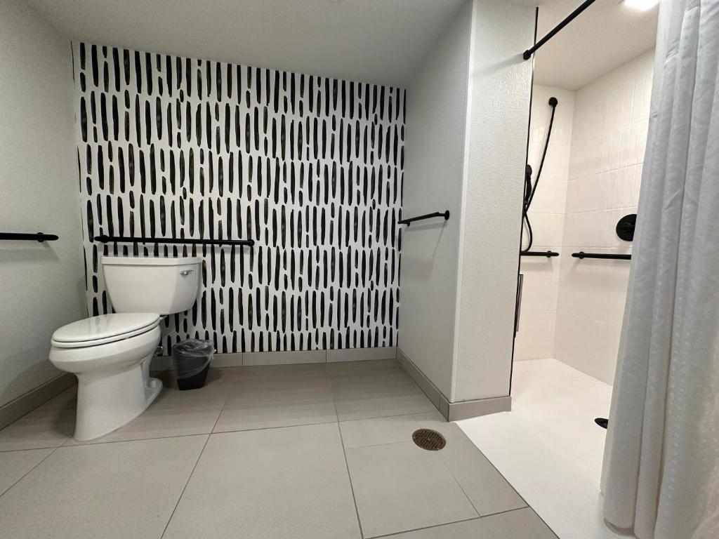 奥斯汀Atwell Suites Austin Airport, an IHG Hotel的白色的浴室设有卫生间和淋浴。