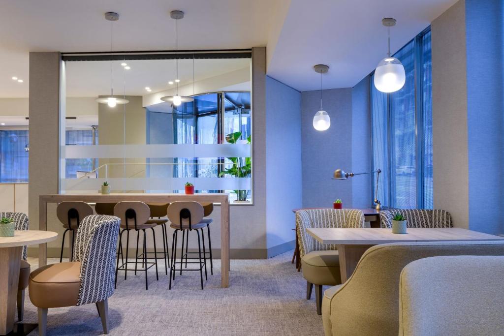 马德里马德里卡尔顿万豪AC酒店的一间配备有桌椅的用餐室和蓝色的墙壁