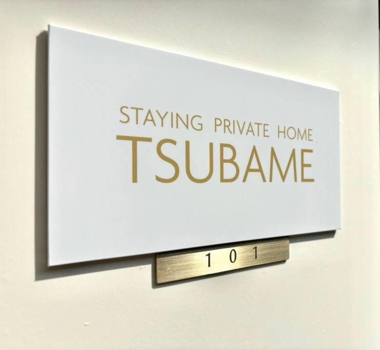 大阪TSUBAME 101 staying private home的墙上的一个标牌,上面写着留宿在分区的私人住宅