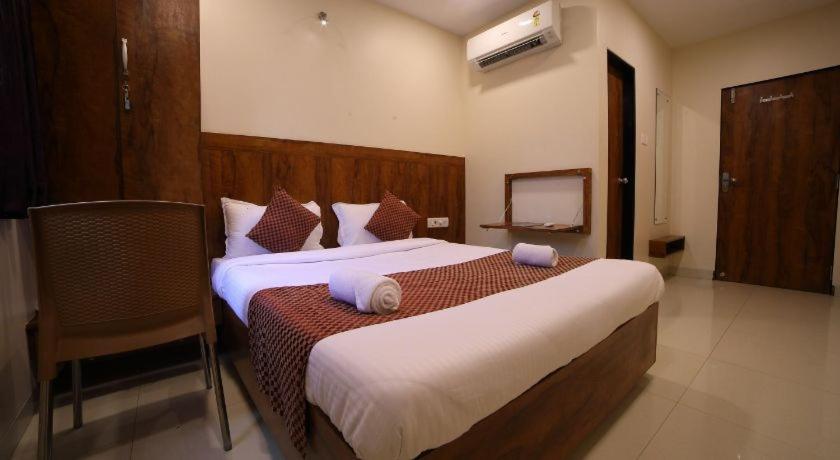 孟买New Prakash Intl Airport的酒店客房,配有两张床和椅子