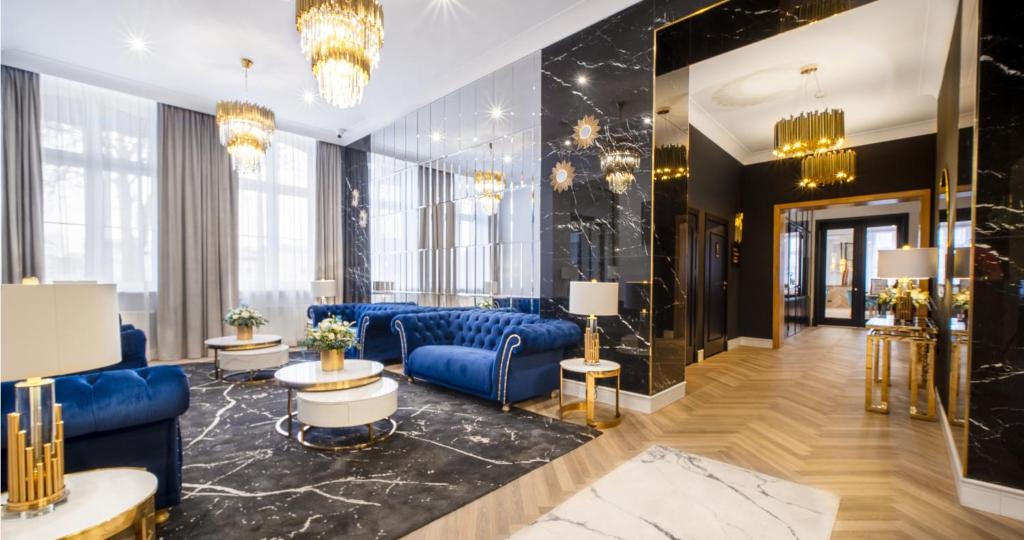 乔左维尔考普尔斯基Hotel Pavco的大堂设有蓝色的沙发、桌子和窗户。