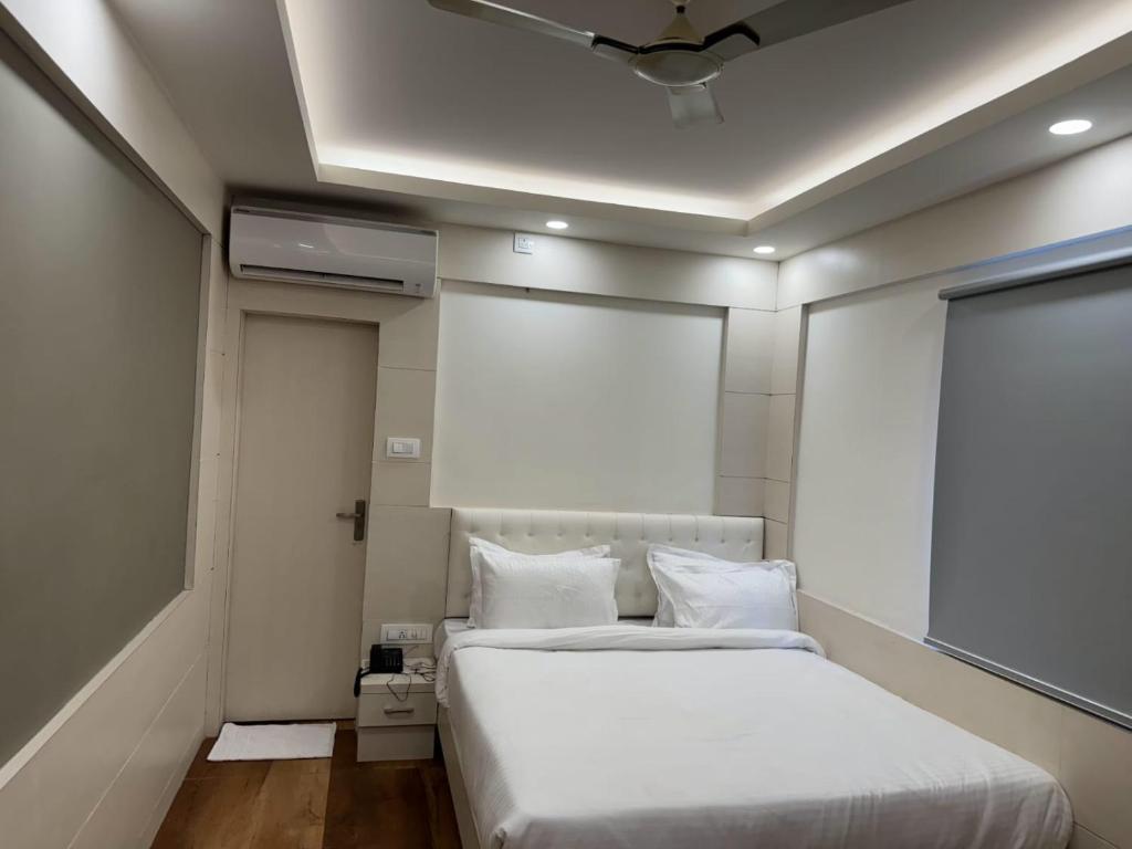 德奥加尔Hotel Taj Akash的卧室配有白色的床和天花板