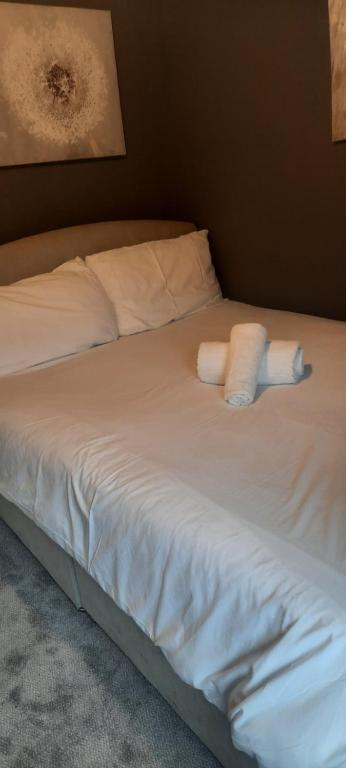戈尔韦Boutique Guest House的一张带白色床单的床和两张毛巾
